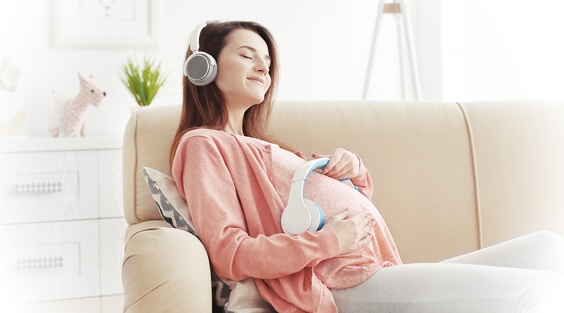 Mujer embarazada colocando música en el vientre