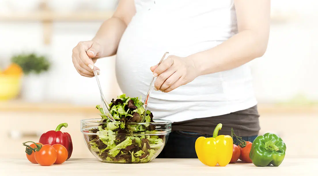 Mujer embarazada preparando alimentos