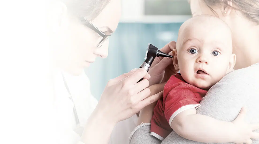 Bebé es revisado del oído por un médico