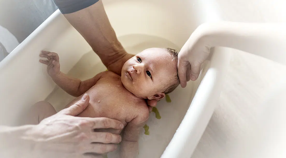 Bebé recibiendo su primer baño