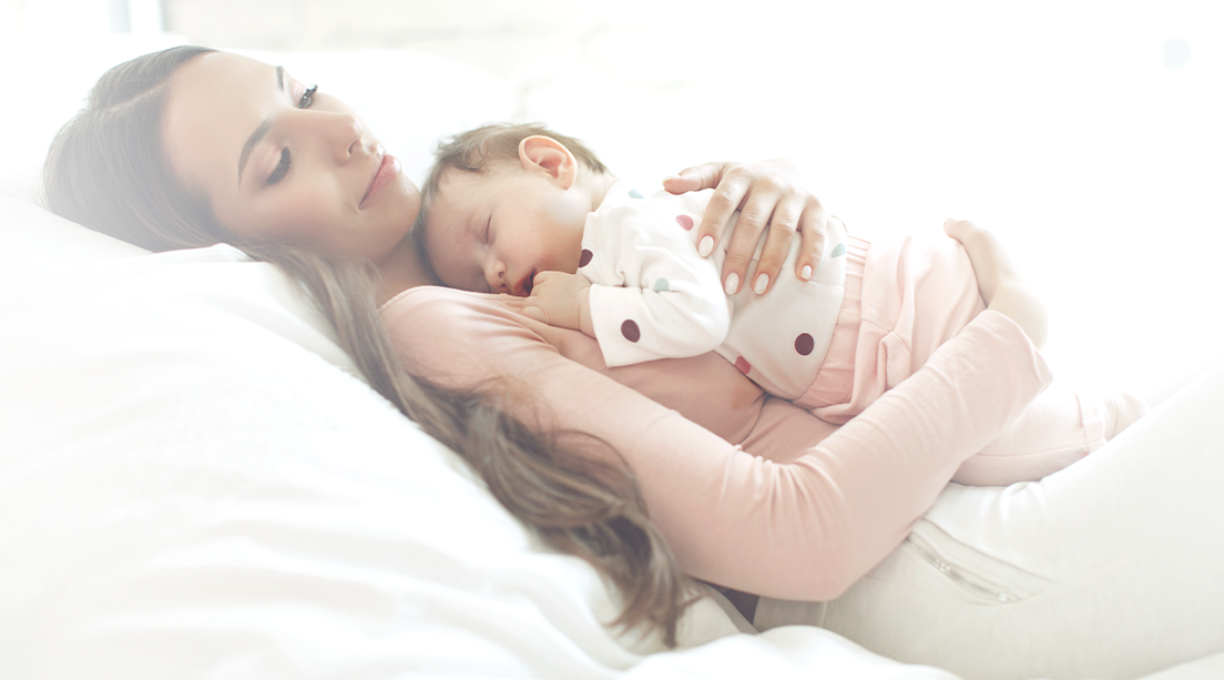 Mamá recostada con su bebé sobre el pecho