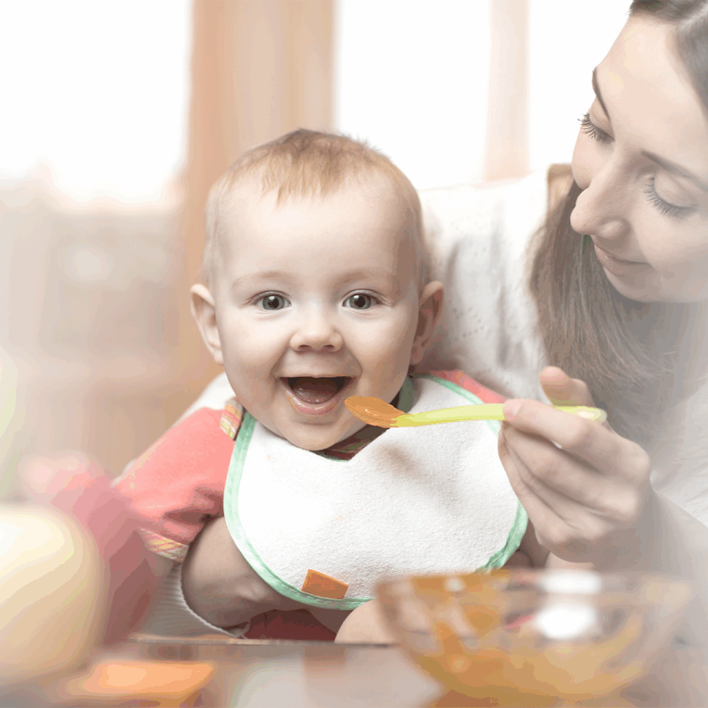 Bebé feliz iniciando la alimentación complementaria con una papilla