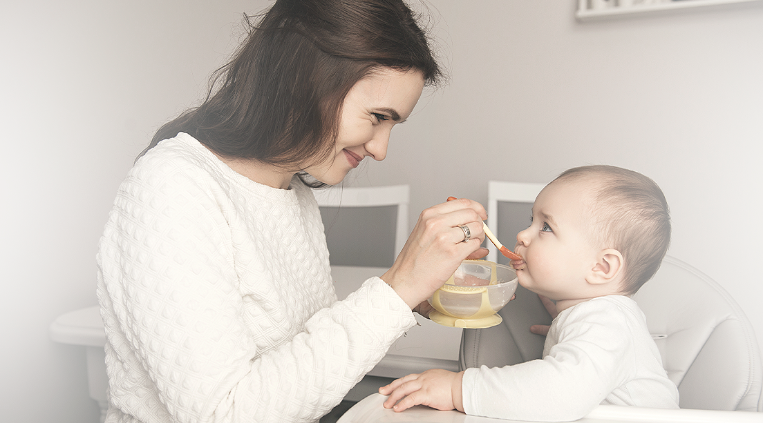 Bebé iniciando la alimentación complementaria acompañado de mamá