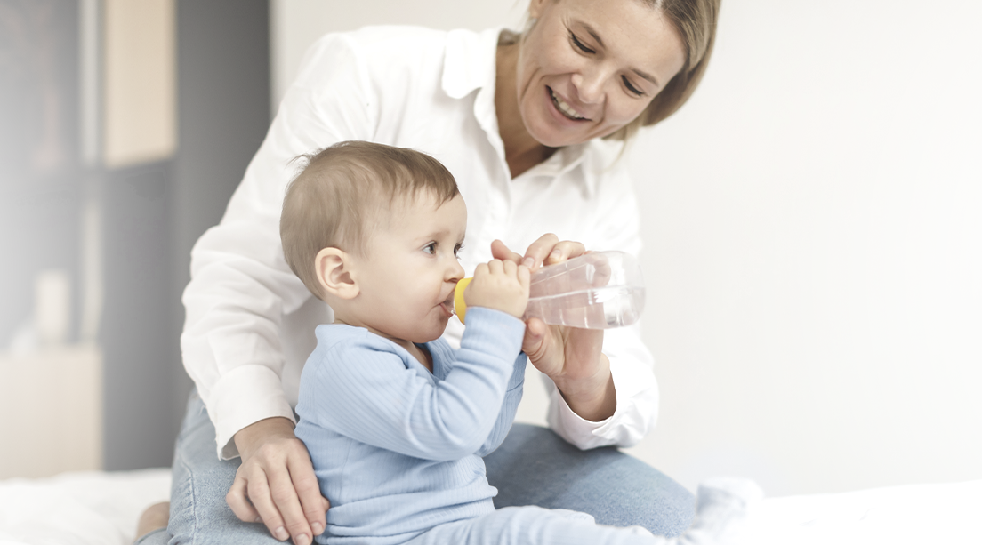 Bebé hidratándose acompañado por mamá