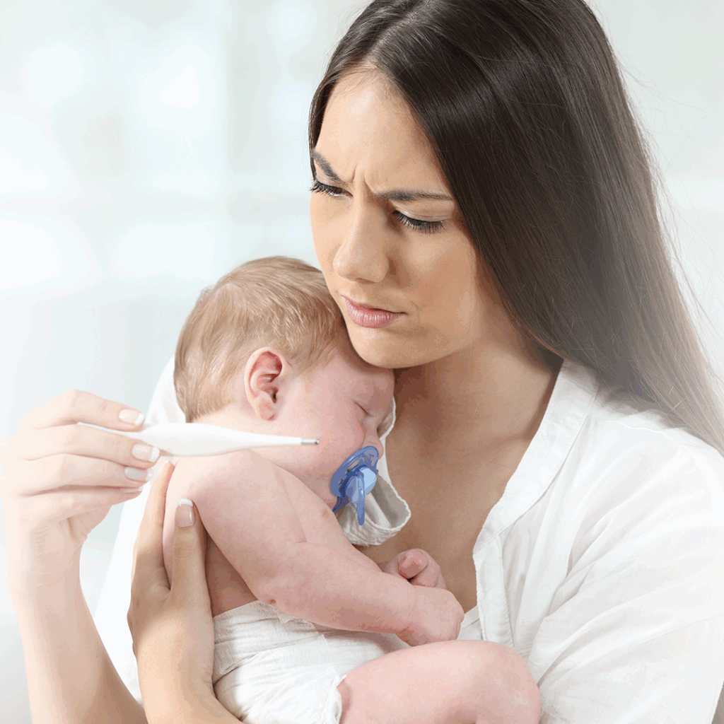 Mamá le mide a la temperatura a su bebé con un termómetro