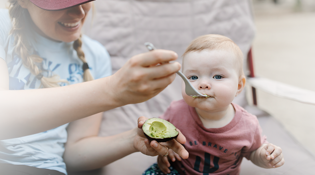 Mamá alimenta a su bebé con super alimentos como el aguacate