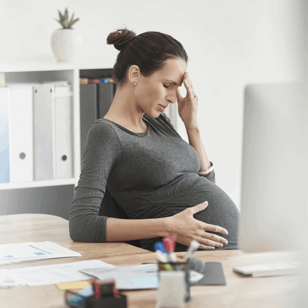 Mujer trabajando en su oficina, durante el tercer trimestre de embarazo