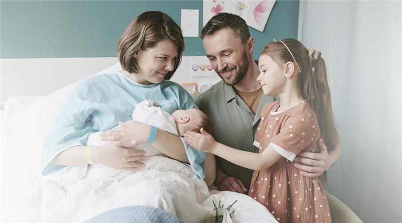 Familia recibiendo la llegada de un nuevo bebé a casa.